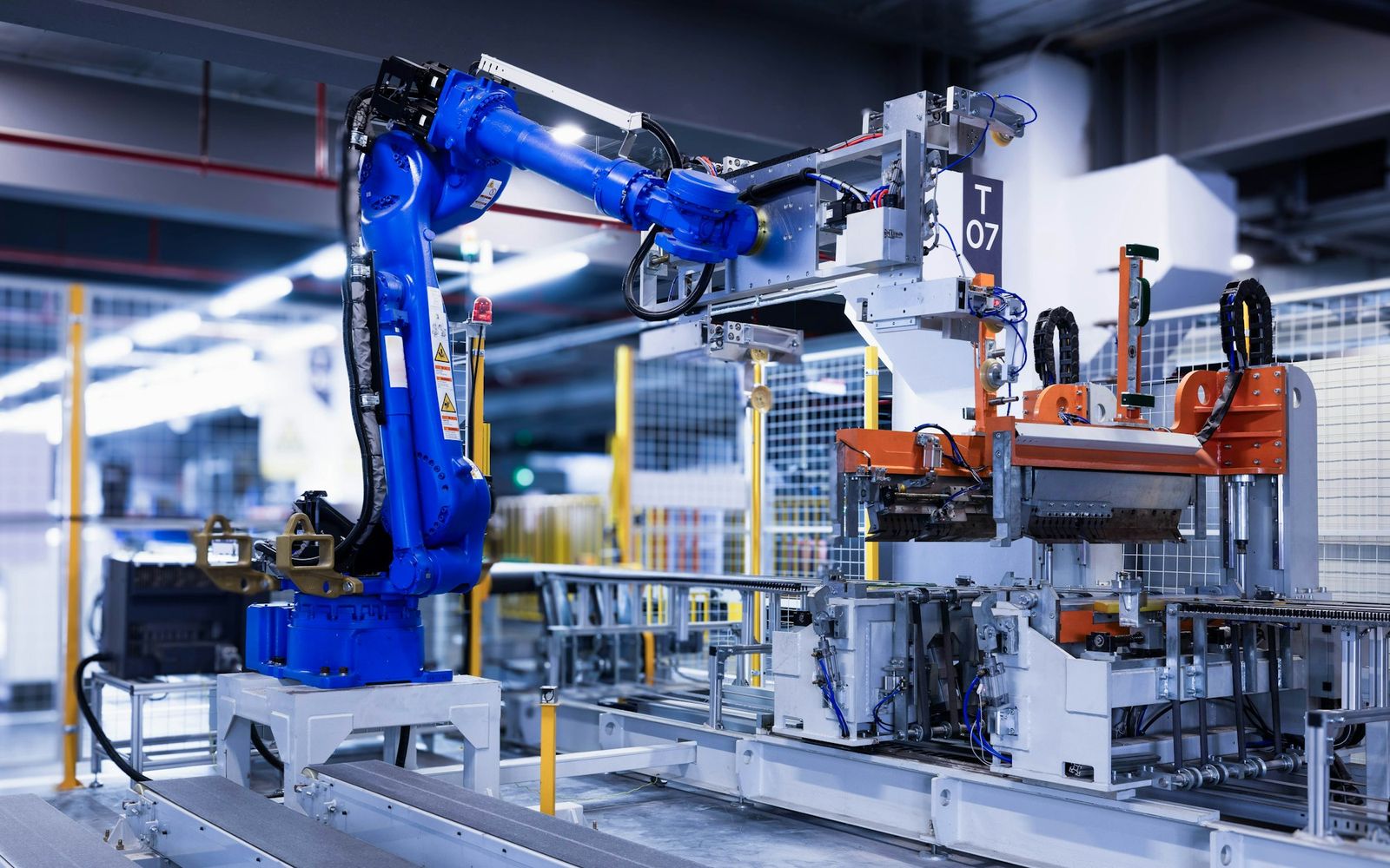 Blue industrial robot arm working on a factory assembly line