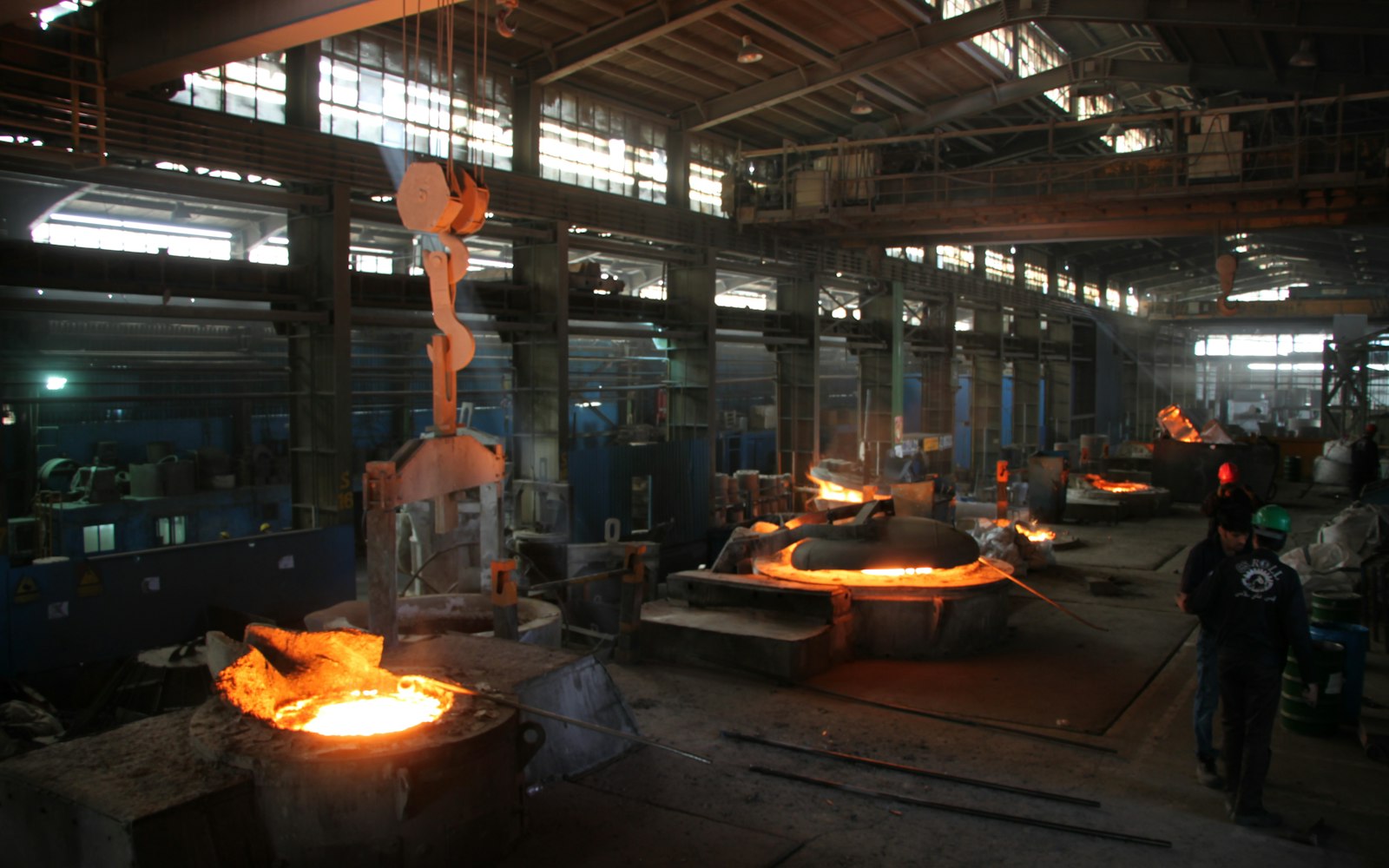 Molten metal being poured inside an industrial foundry