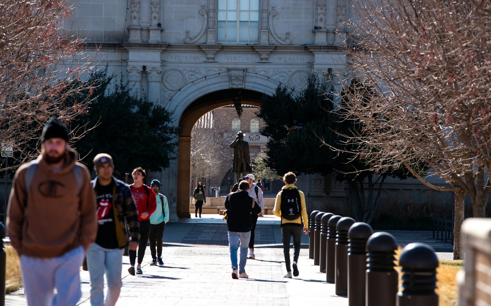 Students walking through a university campus archway