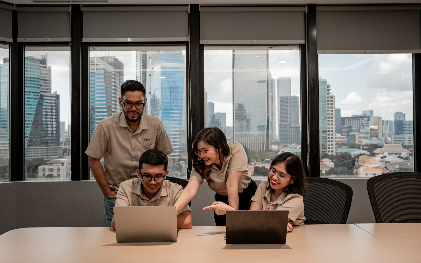 Team gathered around laptops in a bright office